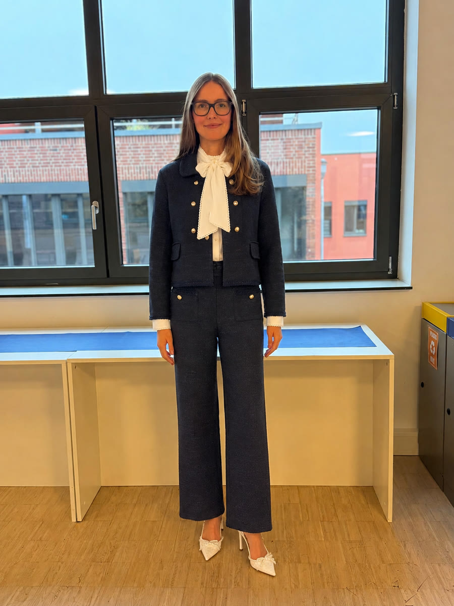 The same photo, wearing the bouclé outfit: jacket, blouse and trousers